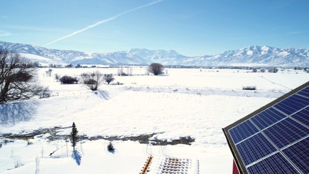 aerial-of-a-house-with-solar-panels-during-the-winter-SBI-350825531